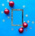 Christmas composition. Photo frames and red baubles on bright blue background. Christmas, winter, new year concept. Royalty Free Stock Photo