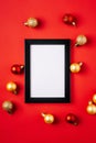 Christmas composition with picture frame mockup. Red and golden ornament and baubles Royalty Free Stock Photo