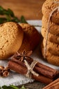 Christmas composition with pile of cookies, cinnamon and dried oranges on light wooden background, close-up. Royalty Free Stock Photo