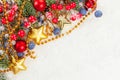 Christmas composition with pine branch, gold stars, garland, holly berries on white snow background. Xmas flat lay, top view Royalty Free Stock Photo