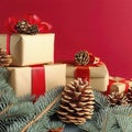 Christmas composition of pine cones, spruce branches and stack of gift boxes on red background Royalty Free Stock Photo