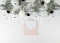 Christmas composition, pink envelope, white and silver decorations, fir tree branches, silver stars confetti on white background. Royalty Free Stock Photo