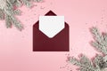 Christmas composition, red envelope, white card, fir tree branches, silver stars confetti on pink background. Royalty Free Stock Photo