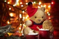 Christmas composition. A red mug with marshmallows stands in front of a Teddy bear in a red cap on the background of the lights of Royalty Free Stock Photo