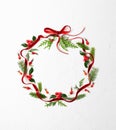 Christmas composition  with red ribbon, branches of spruce and holly with red berries in shape of Christmas bauble on white Royalty Free Stock Photo