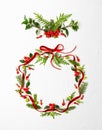 Christmas composition  with red ribbon, branches of spruce and holly with red berries in shape of Christmas bauble on white Royalty Free Stock Photo