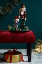 Christmas composition on the red velvet bench with decoration, gifts, wreath, nutcracker and accessories. Royalty Free Stock Photo