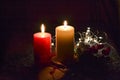 Christmas composition: red and white burning candles on a festive table on a dark background. Gingerbread, tinsel, festoon. Royalty Free Stock Photo