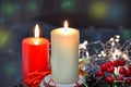 Christmas composition: red and white burning candles on a festive table on a dark background. Gingerbread, tinsel, festoon. Royalty Free Stock Photo