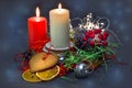 Christmas composition: red and white burning candles on a festive table on a dark background. Gingerbread, tinsel, festoon. Royalty Free Stock Photo