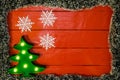 Christmas composition on red wooden board with Christmas garland and decorations. Creative composition with border and copy space Royalty Free Stock Photo