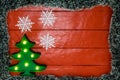 Christmas composition on red wooden board with Christmas garland and decorations. Creative composition with border and copy space Royalty Free Stock Photo