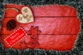 Christmas composition on red wooden board with Christmas garland and decorations. Creative composition with border and copy space Royalty Free Stock Photo