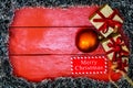 Christmas composition on red wooden board with Christmas garland and decorations. Creative composition with border and copy space Royalty Free Stock Photo