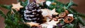 Christmas composition rystic style with handmade fir wreath, cone and homemade cookies on a wooden basket. Decorated with citrus,