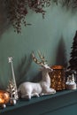 Christmas composition on the shelf in the living room interior. Beautiful decoration. Christmas trees, candles, stars, light. Royalty Free Stock Photo