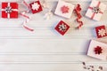 Christmas composition. Small red and white gift boxes with bows, spirals of ribbons. Blank background, copy space. Royalty Free Stock Photo