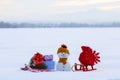 Christmas composition with snowy background. Snowman with red bag with the snowflake on the sledge. Colorful gift box. Royalty Free Stock Photo