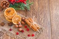 Christmas composition with spruce tree branches, cinnamon sticks, dried slices of oranges, nuts and anise on wooden background. Royalty Free Stock Photo