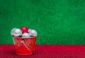 Christmas composition. Ssilver a red balls in a red bucket on a green and red background. Copy space.