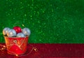 Christmas composition. Ssilver a red balls in a red bucket on a green and red background. Copy space.