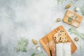 Christmas composition with stollen cake on a wooden board, cutlery and gift on gray background. Flat lay