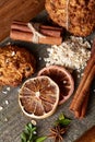 Christmas composition with chocolate biscuits, cinnamon and dried oranges on wooden background, close-up.