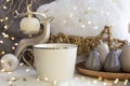 Christmas composition with tea coffee cup, fur pillow, candle, deer and Xmas baubles on New Year background with bright lights and Royalty Free Stock Photo