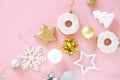 Top view of Christmas tree decorations snowflakes, stars, balls, donuts of gold, white and silver on a pink Royalty Free Stock Photo