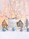 Christmas composition with toy houses, lights, twigs and festive decorations. Christmas or New Year greeting card