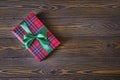 Christmas composition. Christmas tree branches and red gift box on the old wooden table