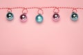 Christmas composition, trendy colors. Banner of shiny christmass garland with pink and skyblue balls over pink background