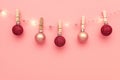 Christmas composition, trendy colors. Garland made of pink and red shine balls on pink background. Christmas, winter, new year