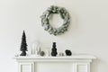 Christmas composition on the white chimney at the living room interior with beautiful decoration. Christmas tree and wreath. Royalty Free Stock Photo