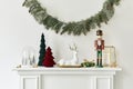 Christmas composition on the white chimney at the living room interior with beautiful decoration. Christmas tree and wreath. Royalty Free Stock Photo