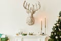 Christmas composition on the white chimney at the living room interior with beautiful decoration. Christmas tree and wreath.