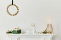 Christmas composition on the white chimney at the living room interior with beautiful decoration. Christmas tree and wreath. Royalty Free Stock Photo