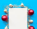 Christmas composition. White mockup blank and baubles on bright blue background. Royalty Free Stock Photo