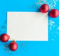 Christmas composition. White mockup blank and baubles on bright blue background. Royalty Free Stock Photo