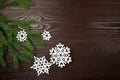 Christmas composition with white paper snowflakes and fir tree branch on wooden background Royalty Free Stock Photo