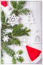 Christmas composition on a white background. Christmas tree branches, Santa Claus hat, decorative snowflakes and a small house. To Royalty Free Stock Photo