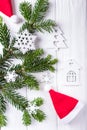 Christmas composition on a white background. Christmas tree branches, Santa Claus hat, decorative snowflakes and a small house. To Royalty Free Stock Photo