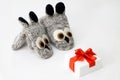 Christmas composition. Woolen knitted mittens in dogs with white gift box red ribbon. isolated white.