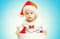 Christmas concept - beautiful baby in santa red hat gets out of the container