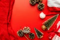 Christmas socks, gifts,pine cones, santa`s hat and fir trees on red background top view flat lay Royalty Free Stock Photo