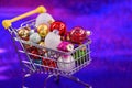 christmas concept, close up view of shopping cart full of colorful xmas baubles