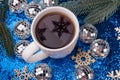 Christmas concept. Cup of tea with snowflake shadow stay among holidat decorations, pine tree branches on shiny blue background. Royalty Free Stock Photo