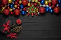 Christmas concept decoration with new year gift boxes with red ribbon, fir branches, pine cone on black wooden background Royalty Free Stock Photo