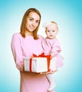 Christmas concept - happy smiling mother and baby in pink dress with box gift Royalty Free Stock Photo