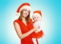 Christmas concept - happy smiling mother and baby in santa red hats Royalty Free Stock Photo